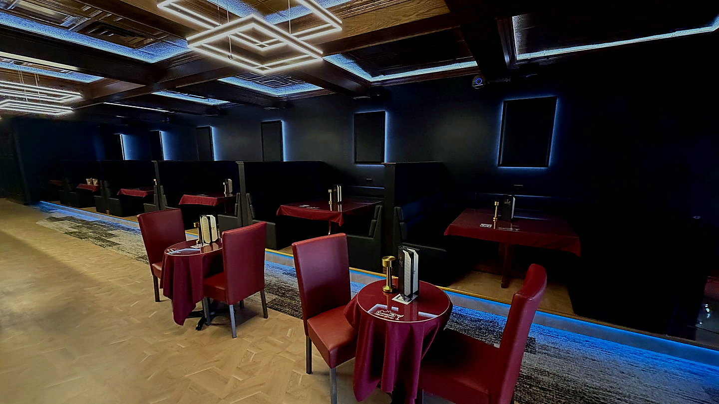 CK Downtown main lounge with booth tables, red chairs, bar seating, and ceiling lights
